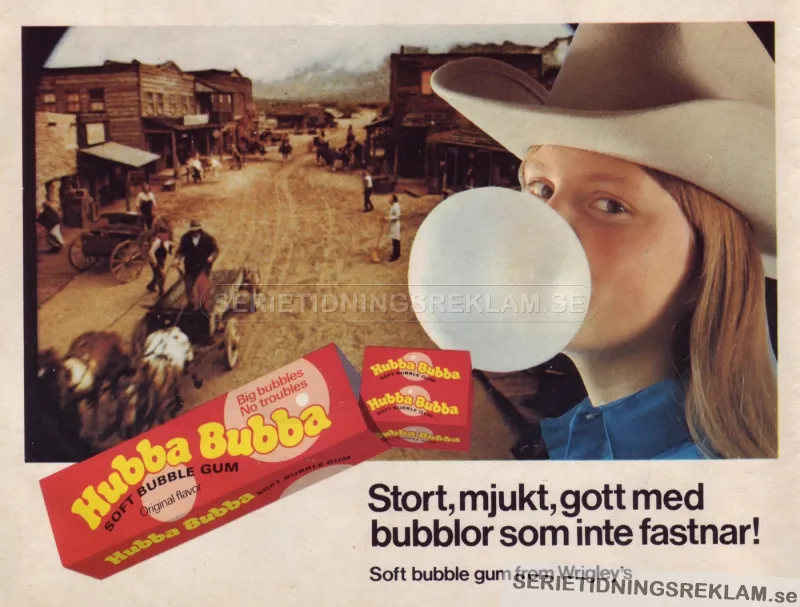 En tjej som tuggar Hubba Bubba och blåser en stor bubbla står framför en scen hämtad från en westernstad med hästar och vagnar